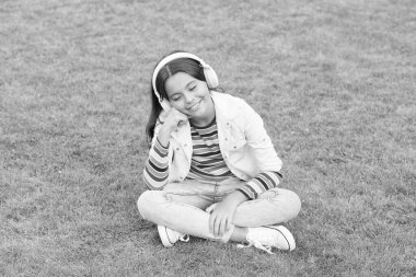 zengin hayal gücü. Çocuk park doğasında şarkı söylemeyi seviyor. Mutlu çocukluk kavramı. Modern hayatta dijital cihazı kullan. Liseli kız dışarıda dinleniyor. Mutlu çocuk kulaklıkla müzik dinler. Yeşil çimlerin üzerinde küçük bir kız