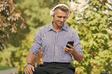 Ses yelpazesi teknolojisi. Mutlu adam müziği akıllı telefondan seçiyor. Kablosuz kulaklık teknolojisi. Yeni teknoloji. Modern hayat. Gezici teknoloji dünyayı birbirine bağlıyor