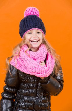 Şapkalı kız, pembe atkı, turuncu arka planda siyah ceket.