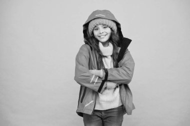 Kış tatili Koruyucu giysiler. Mutlu gülümseyen çocuk. Tam teçhizatlı. Kayak merkezi konsepti. Kış koleksiyonu. Çocuk şapka ve ceket giyiyor. Aktif boş zaman. Sportif tarzda. Kız kış mevsiminin tadını çıkarıyor