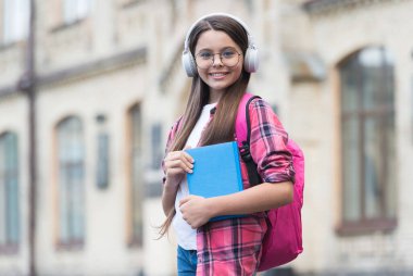 Seyahat ederken dil öğren. Mutlu çocuk kulaklık takıyor. Yabancı dil öğreniyorum. İngilizce okulu. Ses dersi. Çevrimiçi kurslar. Özel ders. Resmi olmayan eğitim. Dil yeterliliği
