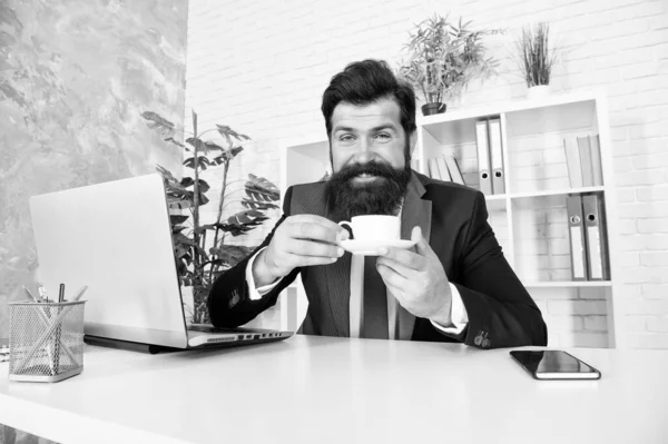 Diskutujte o obchodu s kávou. Muž pohledný šéf sedí v kanceláři a pije kávu. Pohodlný pracovní prostor. Dobré ráno. Vousatý hipsterský společenský oblek, relaxující s kávou. Kancelářské životní návyky. Respektovatelný ředitel — Stock fotografie