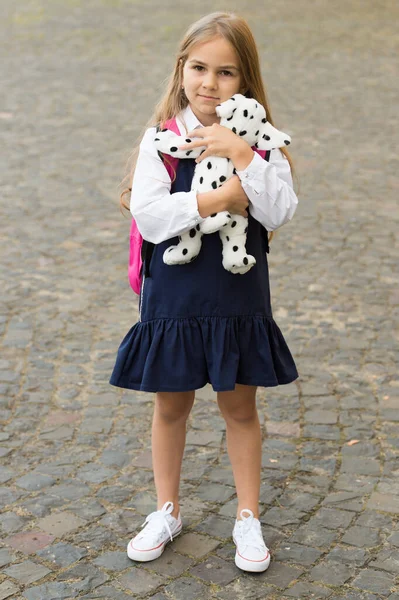 学習は遊びから始まります。小さな子供は屋外でおもちゃの犬を保持します。ふりをしろ。学校の必需品に戻る。幼児教育。プレイスクールとアフタースクール。遊びや交流 — ストック写真