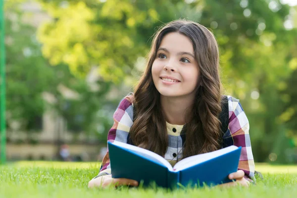 Lezen helpt je zaad van kennis groeien. Gelukkig kind las boek liggend op groen gras. Kennisdag. 1 september. Terug naar school. Basisonderwijs. Schoolbibliotheek. Naschoolse club. Breid je geest uit — Stockfoto