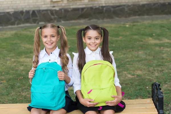 Estudien juntos para lograr más. Chicas felices estudian en la escuela primaria. Los niños pequeños sostienen bolsas al aire libre. Estudio en casa. Educación y escolaridad. Enseñanza privada. De vuelta a la escuela. Dedicado al estudio — Foto de Stock