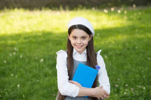 Kleines intelligentes Mädchen mit Buch im Freien sonniger Tag, anspruchsvolles Schulmädchenkonzept — Stockfoto