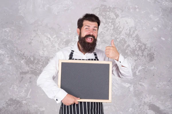 Man good looking hospitable restaurant waiter with blackboard copy space, recommend concept