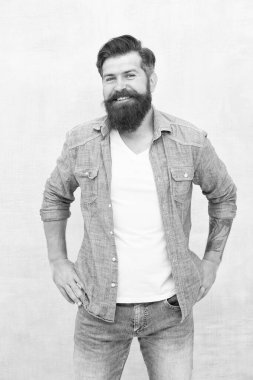 İyi titreşimler. Sakallı ve bıyıklı karizmatik berber. Kişilik ve karizma kavramı. Sakallı, bakımlı bir hippi. Yakışıklı adam moda kıyafetleri giyiyor. Denim moda trendleri. Berber dükkanı modası