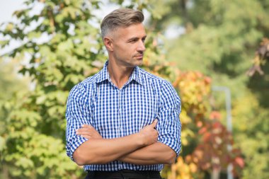 Başarılı ve karizmatik bir adam. Yakışıklı erkek, saçları beyazlamış. Olgun adam dışarıda ellerini çaprazladı. Sonbahar veya bahar gündelik modası. Erkek modası ve güzellik. Adil ve sıradan bir gün.