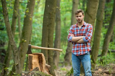 Baltayla poz veren yakışıklı bir adam.
