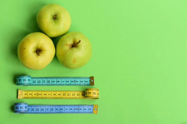 Sport e sano stile di vita simboli. Mele vicino a rulli di nastro di misurazione — Foto Stock