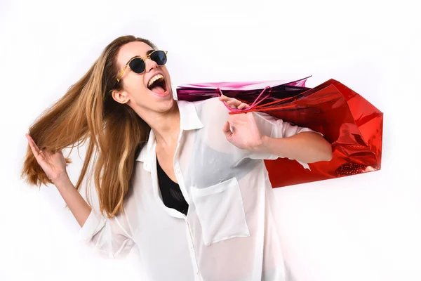 Lady hält rote und rosa Einkaufstüten in der Hand. Mädchen mit Sonnenbrille — Stockfoto