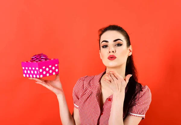 Концепция воздушного поцелуя. Женщина держит ярко-розовый пакет подарков и посылает воздушный поцелуй. — стоковое фото