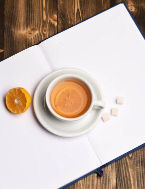 Açık bir kitaba şeker küpleri yerleştirilmiş sıcak içecek