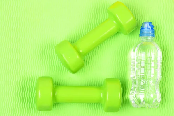 Para zielonych hantli fitness i butelka wody. — Zdjęcie stockowe