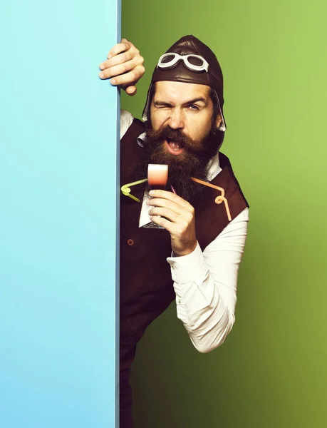 Funny handsome bearded pilot on blue green studio background — Stock Photo, Image