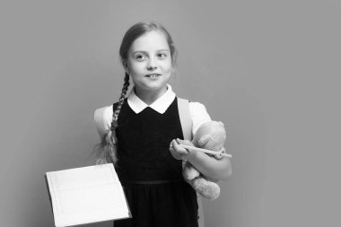 Kurnaz yüzlü, örgülü, yeşil elbiseli liseli kız.