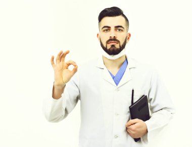 Sakallı doktor hastalık geçmişi için not defteri tutuyor.