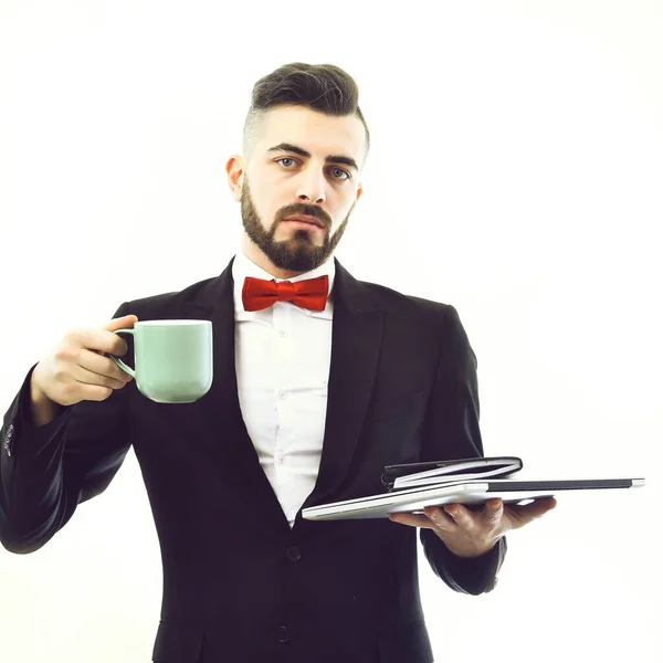 Baard zakenman in pak houdt laptop, organisator en blauwe beker — Stockfoto