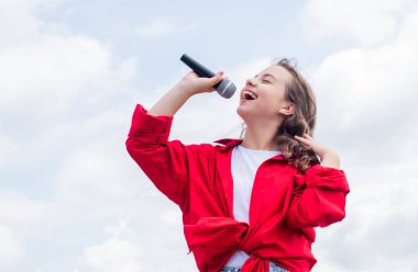 piece of music. make your voice louder. teen girl singing song with microphone. having a party. Happy kid with microphone. karaoke concept. Singing Songs. Lifestyle and People Concept clipart