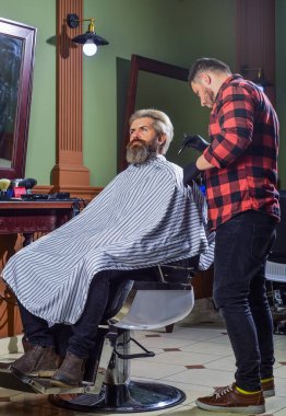 Yeni tarzını seviyor. Sakal ve bıyık. Berber dükkanında profesyonel kuaför. Şık erkek sakalı portresi. Tıraş. Berber dükkanındaki kuaför. Kuaförde hippi tıraşlı bir adam.