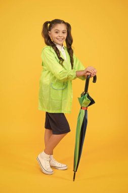 Şemsiyeli küçük bir kız. Öğrenci kız su geçirmez yağmurluk. Keyfim yerinde. Korunmuş ve mutlu hissediyorum. Sonbahar sezonu için aksesuar. Sonbahar çocuk modası. Yağmurlu havada kuru ve rahat