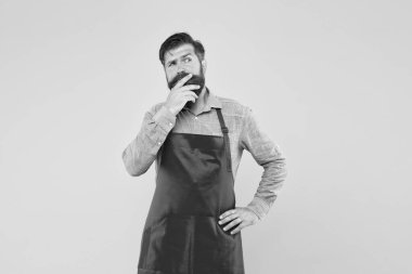 Profesyonel şef. Yakışıklı erkek barista çalışıyor. Olgun bir barmen. Yeni işini. Tezgahtar üniformalı adam. Sarı arka planda kırmızı önlüklü rüya adam. Kendine güvenen ifade