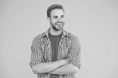 Erkek güzelliği ve moda. Erkekler için moda. Erkekler için güven anlamına geliyor. Kollarını çapraz yapmış şık bir adam. Karizmatik manken. Yakışıklı, tıraşsız adam. Erkek kareli gömlek giyer.