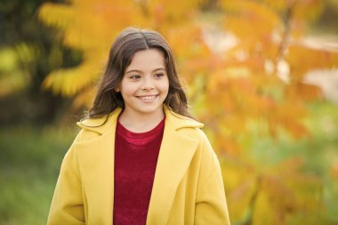 Sıcak sonbahar günleri için eğlenceli aktiviteler. Sonbahar yapılacaklar listesi. Sonbahar yürüyüşünde neşeli bir çocuk. Sonbahar için en iyi seçim kalın palto. Sonbahar mevsimi konsepti. Çocuk sonbahar havası için ceket giyiyor.