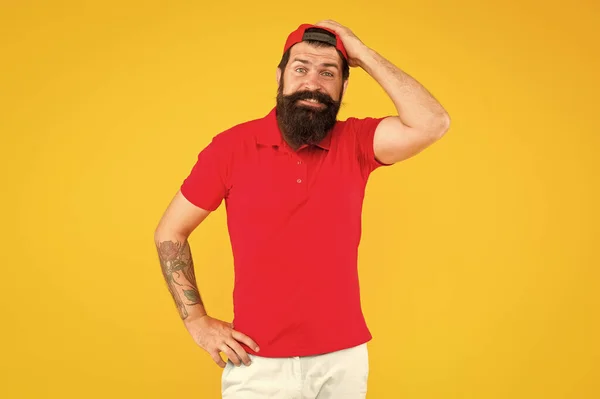 Sorry. Forgot about your order. Hiring shop worker. Hipster cashier. Delivery service. Man bearded tattooed hipster cap cashier uniform yellow background. Cashier concept. Salesman cashier career