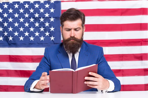 Hipster homem leitura livro EUA bandeira fundo, professor universitário conceito — Fotografia de Stock