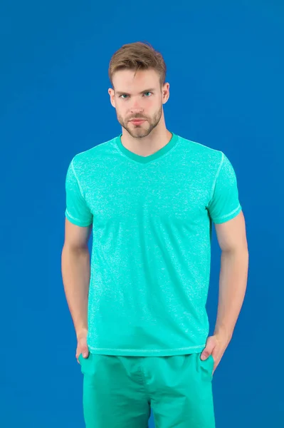 Mann in T-Shirt und Shorts auf violettem Hintergrund. Kerl in blauer Freizeitkleidung. Macho in aktiver Kleidung für Workout oder Training auf violettem Hintergrund. Sport Mode Stil und Trend. Fitness und Fitness — Stockfoto