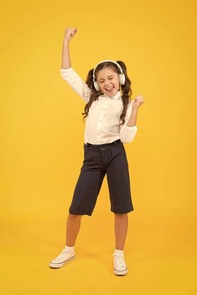 Enseignement en ligne. Cours d'écoute. Les enfants aiment la musique. Enseignement audio. Enseignement à domicile. Casque d'élève de petite fille. Enfant heureux écouter de la musique. Chante une chanson. Livre audio. Éducation et concept amusant — Photo