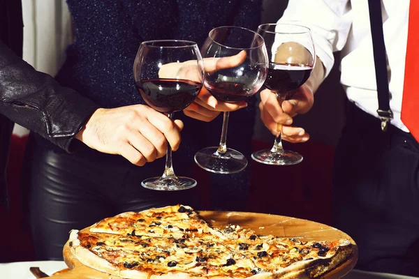Trzy kieliszki z czerwonym winem w rękach kobiet i mężczyzn — Zdjęcie stockowe