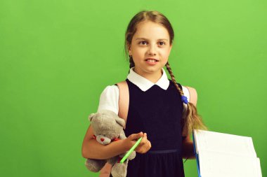 Okul üniformalı, örgülü ve pembe sırt çantalı bir öğrenci.