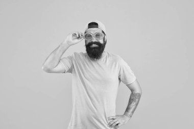 Hippi parti gözlüğü takıyor. Göz sağlığı. Görme kontrolü. Güzel görüş. Eğlence ve eğlence. Komik bir aksesuar. Erkek gözlüğü modeli. Komik güneş gözlükleri. Güneş gözlüklü, turuncu arka planlı sakallı adam.