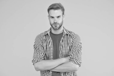 Karizmatik manken. Yakışıklı, tıraşsız adam. Adam kareli gömlek giyiyor. Erkek güzelliği ve moda. Erkekler için moda. Erkekler için güven anlamına geliyor. Yakışıklı adam kollarını kavuşturmuş duruyor.