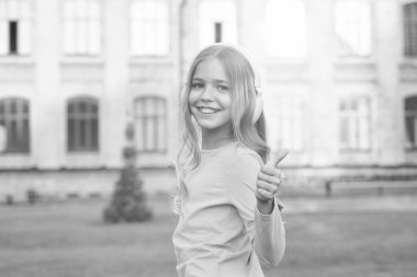 Uzaktan öğrenme. Kulaklık takan mutlu küçük kız. Stereo sesi. Güzel hikayeler dinliyorum. Kendi kendine eğitim. Kablosuz teknolojili kulaklıklar. Küçük çocuk müzik dinliyor modern kulaklıklar