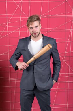 Şiddetle tehdit etmek. Agresif iş stratejisi. İş adamı resmi zarif takım elbisesi pembe arka plan. Tahta sopayı tutan adam. Tüylü adam kendinden emin ve tehditkar görünüyor. Tehdit edici bir hareket.