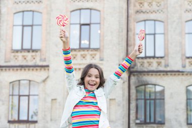 Bahar tatili havası. Olumlu ruh halinde küçük bir güzellik. çocukluk mutluluğu. Renkli ve tatlı. Lolipopu olan hippi çocuk. Mutlu çocuklar günü. Küçük kızın kıvırcık saçları var. Kaygısız zaman geçirmek