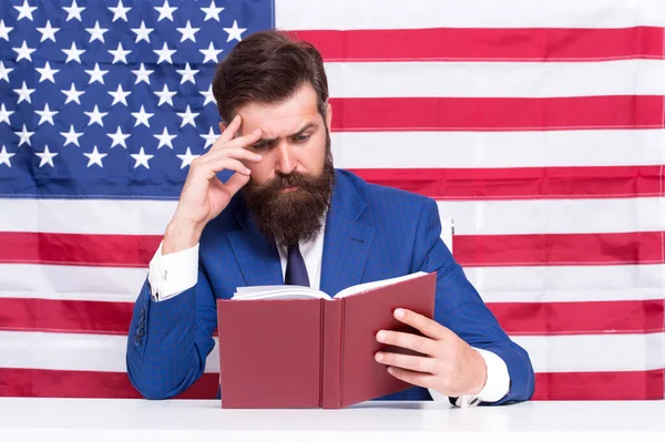 Hipster homem leitura livro EUA bandeira fundo, aprendendo o conceito de lei — Fotografia de Stock
