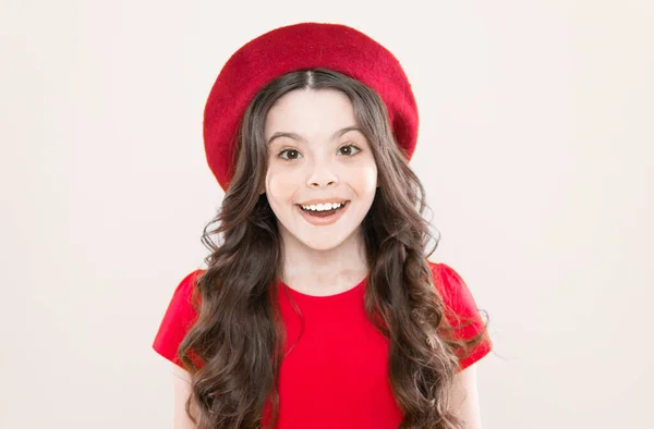 Kid cute face with adorable curly hairstyle wear beret hat. Little fashionista. Perfect curls. Little girl grow long hair. Styling of curly hair. Hairdresser service. Kid girl long healthy shiny hair — Stock Photo, Image