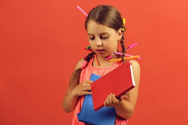 Kızın elinde kırmızı ve mavi kitaplar var. Okula geri dön.