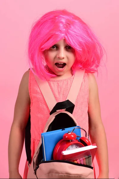 Alumno en uniforme escolar con peluca rosa sobre fondo rosa — Foto de Stock