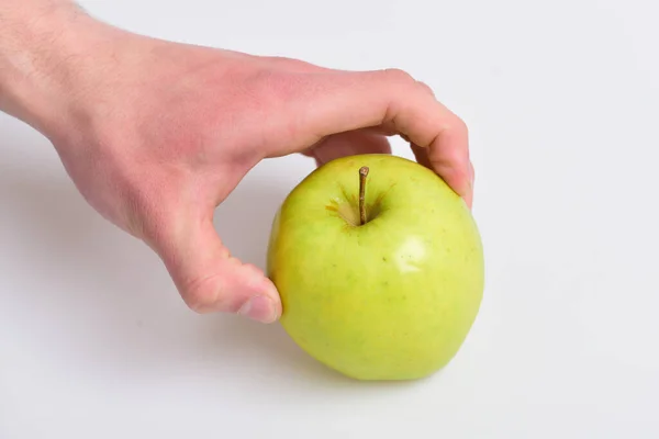 Vitamins and fitness concept. Male hand touches light green apple. — Stock Photo, Image