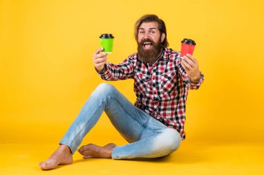 Bunu seçiyorum. Yaşam tarzı konsepti. Kahveli yakışıklı hippi adam. Kahve molası veriyor. Fincandan su içen yakışıklı bir yetişkin. Bir fincan kahve ya da çay al.