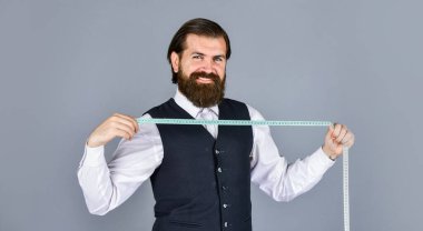 Fikirleri kıyafete dönüştürmek. Erkek kıyafetleri terziliği yapan adam. Vahşi adam moda tasarımcısı. Adam erkekler için kostüm tasarlıyor. Sartor çalışmaya hazır. Resmi ve ofis tarzı. Mezuralı terzi.