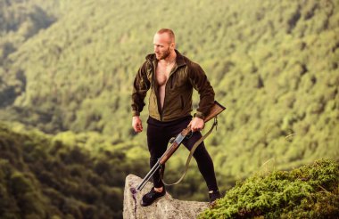 Kaçak avcı uçurumun kenarında duruyor. Kaçak avlanma kavramı. Adam vahşi kaçak avcı, silah ve doğal manzara. Avcı kaçak avcı kurban arıyor. Tüfek doğası olan bir avcı. Yasadışı avlanma
