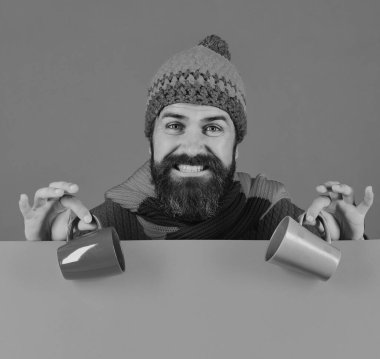 Sakallı adam kahverengi ve yeşil çay fincanları tutuyor..