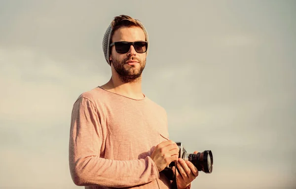 Concept de photojournaliste. Blogueur de voyage. Photographe professionnel. Un reporter de Hipster qui prend des photos. Guy photographe en plein air ciel arrière-plan. Beau photographe gars appareil photo rétro. Réglages manuels — Photo